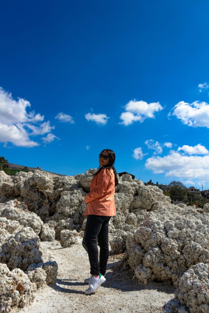 A woman standing on top of a pile of rocks